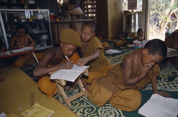 THAILAND, Wat Phra Acha Tong, Young novice Buddhist monks from The Golden Horse Forest Monastery studying together.