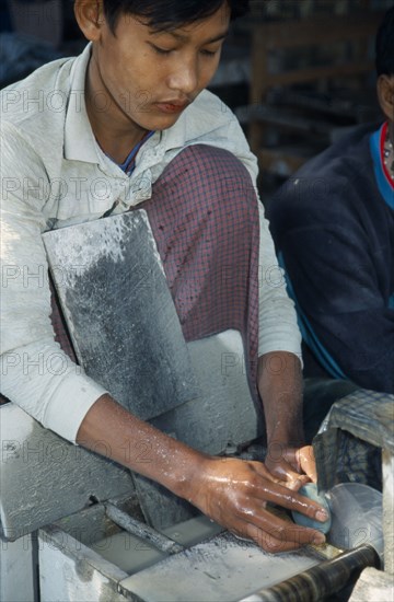 MYANMAR, Mandalay, Jade cutter in central jade market.