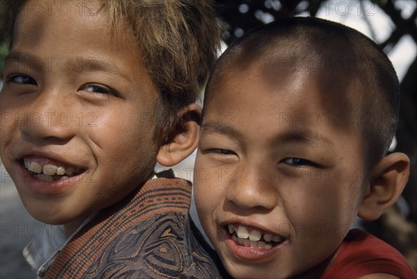 MYANMAR, Amarapura, Portrait of smiling novice monk and temple boy on Lake Taungthaman near Mandalay.