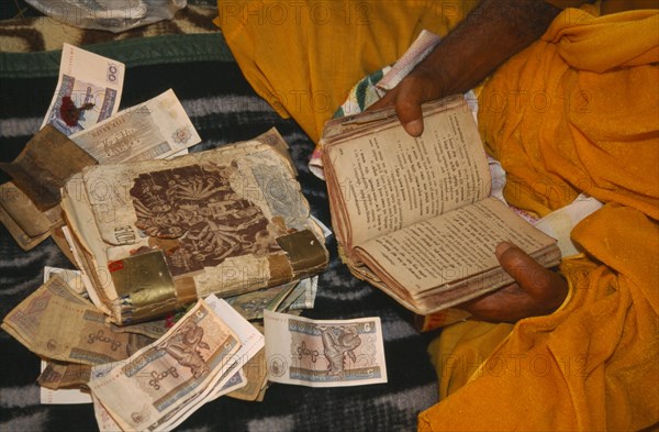 MYANMAR, General, Cropped view of Hindu priest receiving alms during festival at the confluence of the Ayeyarawady north of Myitkyina in upper Myanmar.