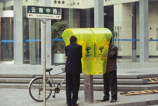 CHINA, Shanghai, People using city centre public telephone.