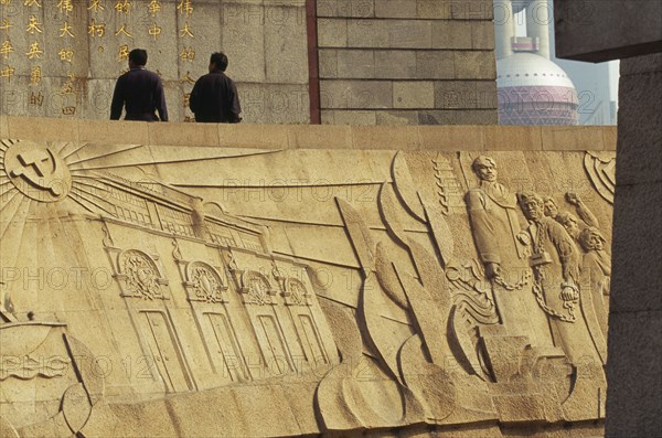 CHINA, Shanghai, The Martyr’s Monument.  Detail of relief carving with two men walking along top of wall above.