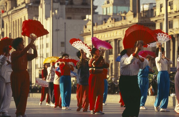 CHINA, Shanghai, Early morning group exercise using fans on the Bund.