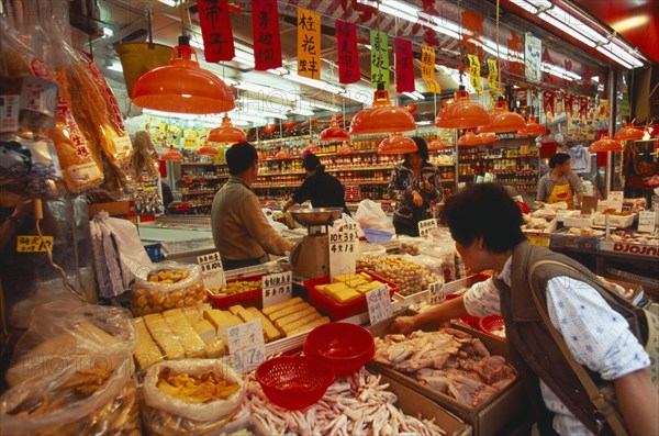 CHINA, Hong Kong, "Wanchi market interior with display of variety of food products, customers and staff."