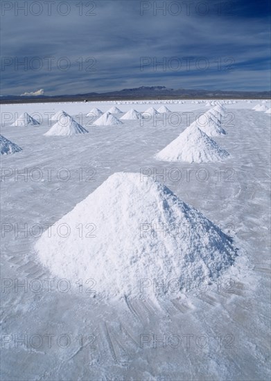 BOLIVIA, Altiplano, Potosi, Salar de Uyuni.  Piles of salt awaiting collection.