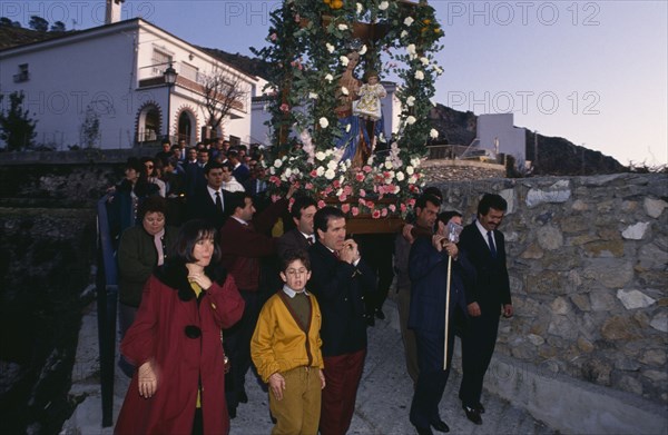 SPAIN, Andalucia, Festivals, Christmas procession through village carrying garlanded statue of the Virgin and Child.