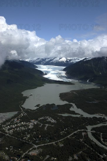 USA, Alaska, Juneau, Aerial view over town and waters leading toward snow covered valley and mountain peaks