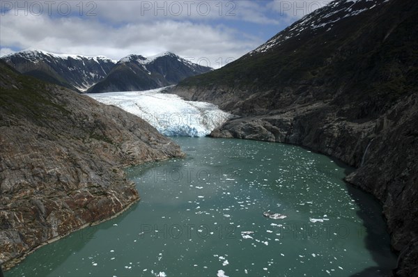 USA, Alaska, Tracy Arm Fjord, View along waterway toward icy slope and mountain peaks beyond