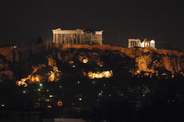 GREECE, Athens, View toward the hilltop Acropolis with the Parthenon and other ruins illuminated at night