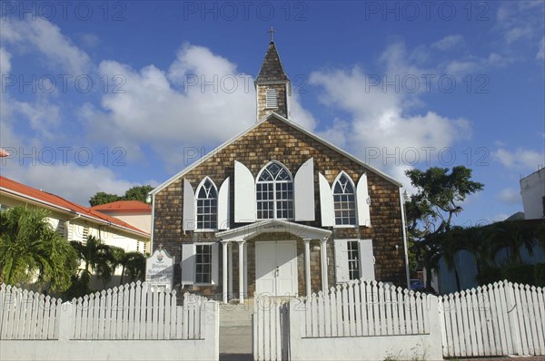 WEST INDIES, St Martin, Small brick church with white shuttered windows and surrounding picket fence
