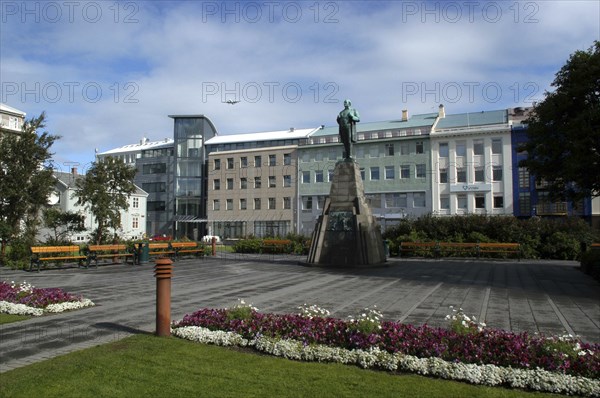 ICELAND, Reykjavik, View over the town Square with floral borders toward central statue and building facades beyond