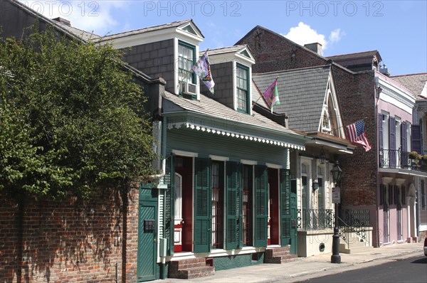 USA, Louisiana, New Orleans, French Quarter. View along row of houses with green shuttered windows and flying flags