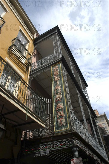 USA, Louisiana, New Orleans, French Quarter. Angled view looking up at ornate ironwork balcony of a restaurant