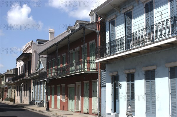 USA, Louisiana, New Orleans, French Quarter. View along row of pastel coloured buildings with ironwork balconies