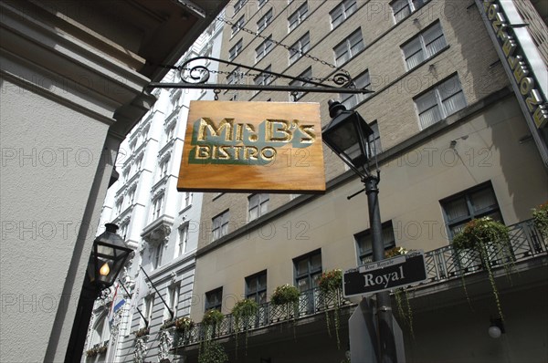 USA, Louisiana, New Orleans, French Quarter. Sign hanging outside Mr B’s Bistro on Royal Street with highrise buildings behind