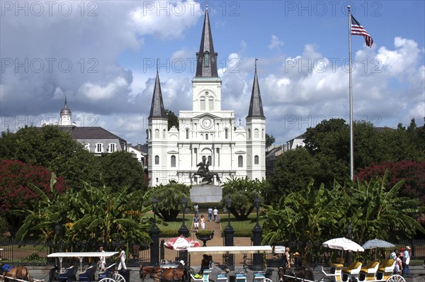 USA, Louisiana, New Orleans, French Quarter. Jackson Square with equestrian statue of Andrew Jackson in front of St Louis Cathedral and horse drawn carriages in the foreground