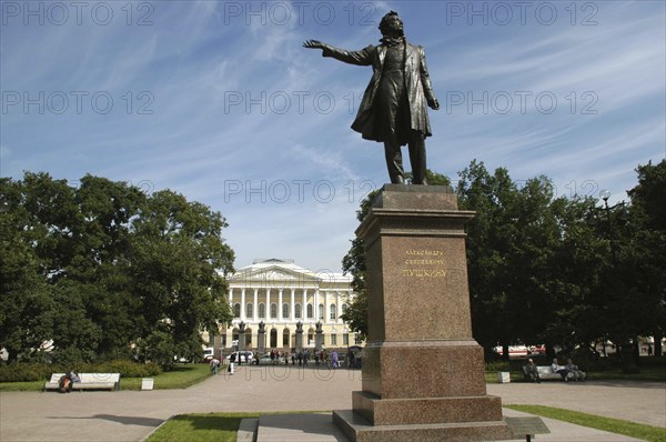 RUSSIA, St Petersburg, Statue in park with the Mikhailovsky Palace and Russian Museum in the distance