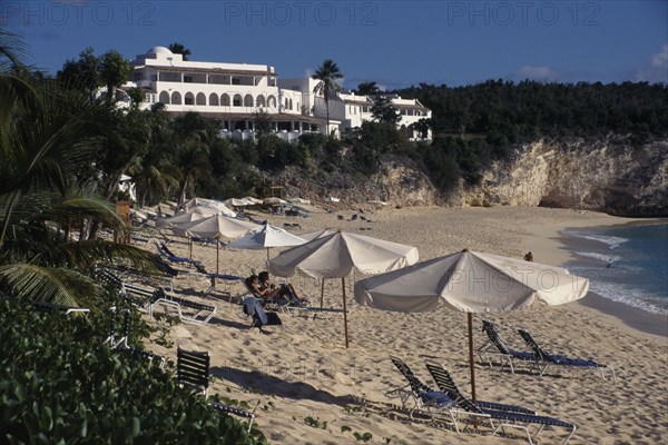 WEST INDIES, French Antilles, St Martin, Samana beach with people sunbathing on loungers and parasols