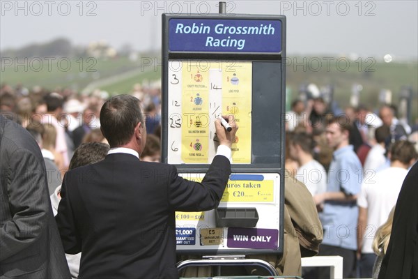 ENGLAND, East Sussex, Brighton, Betting stall at Brighton Race Course with man writing in the odds with a marker