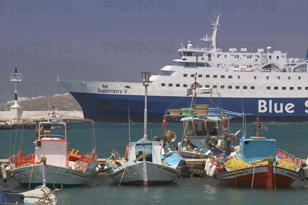GREECE, Cyclades, Mykonos, Passenger ferry in port with colourful fishing boats in the foreground.