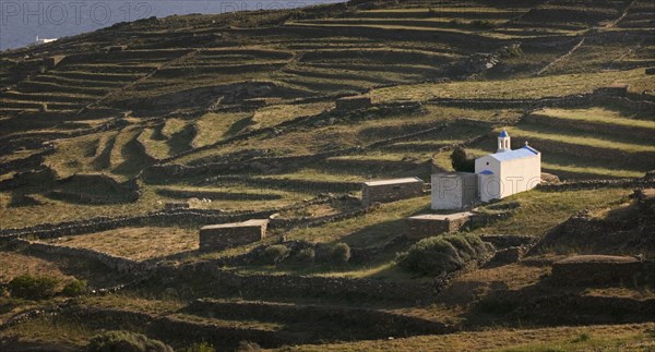 GREECE, Cyclades, Tinos, Religious shrine on a terraced hill side.