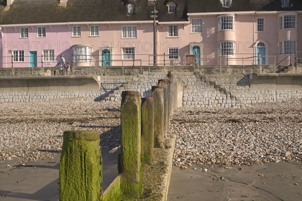 ENGLAND, Dorset, Lyme Regis, View of old fishermens cottages along the waterfront from the beach with a groyne in the foreground.