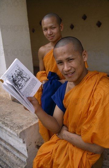 LAOS, Vientiane, Young Buddhist monks with book.
