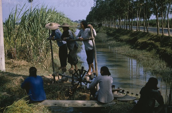 CHINA, Water, Women on treadmill lifting water for irrigation of crops.  This type of treadmill is rarely used today.