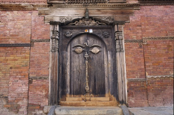 NEPAL, Kathmandu, "Hanuman Dhoka, the old royal palace in Durbar Square.  Detail of medieval carved wooden door in red brick wall."