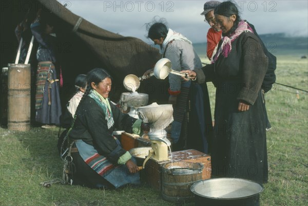 TIBET, People, Tibetan nomad women on the high grasslands with cream seperator brought by travelling salesman.