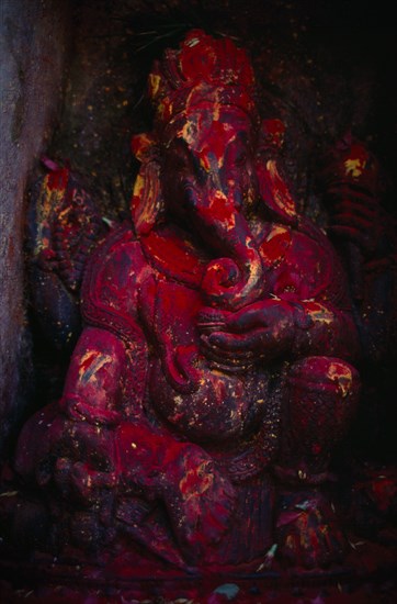 NEPAL, Kathmandu, Godavari, Statue of Ganesh covered in red powder on the side of the Godavari Kunda sacred spring.