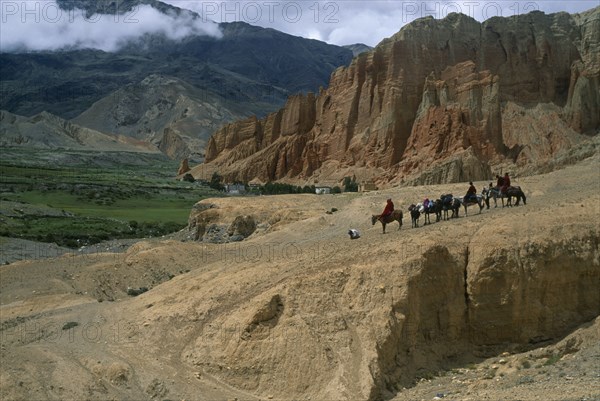 NEPAL, Mustang, Drakhmar , High ranking Tibetan lama and attending monks leaving Drakhmar on horseback.