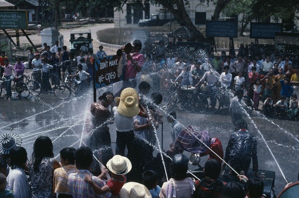 MYANMAR, Mandalay, Buddhist Water Festival.  Crowds spraying water from open topped jeep.