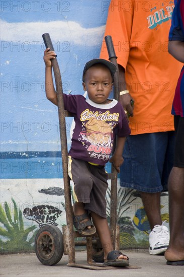 WEST INDIES, St Vincent & The Grenadines, Union Island, Young boy with a balloon in his t-shirt at the Easterval Easter Carnival in Clifton