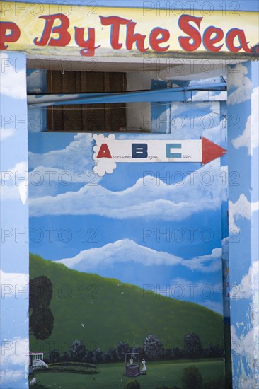 WEST INDIES, St Vincent & The Grenadines, Union Island, Wall painting in Clifton depicting a woman at a well in a green valley