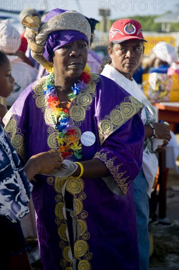 WEST INDIES, St Vincent & The Grenadines, Union Island, Woman handing out food amongst the Baptist congregation in Clifton at Easter morning harbourside service for those lost at sea