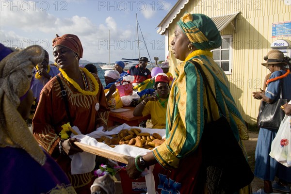 WEST INDIES, St Vincent & The Grenadines, Union Island, Women handing out food amongst the Baptist congregation in Clifton at Easter morning harbourside service for those lost at sea