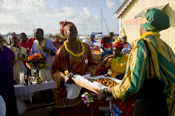 WEST INDIES, St Vincent & The Grenadines, Union Island, Women handing out food amongst the Baptist congregation in Clifton at Easter morning harbourside service for those lost at sea