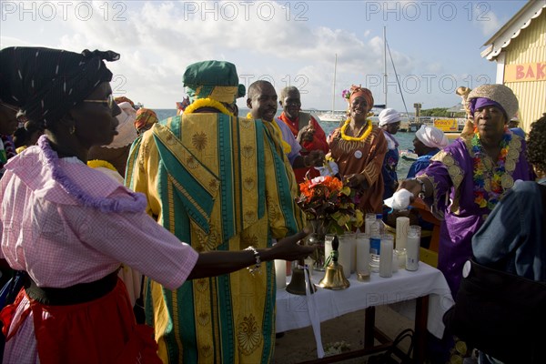 WEST INDIES, St Vincent & The Grenadines, Union Island, Women handing out donated goods amongst the Baptist congregation in Clifton at Easter morning harbourside service for those lost at sea