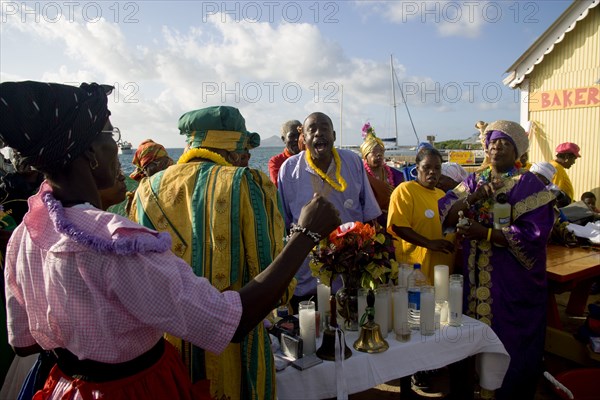 WEST INDIES, St Vincent & The Grenadines, Union Island, Women handing out donated goods amongst the Baptist congregation in Clifton at Easter morning harbourside service for those lost at sea