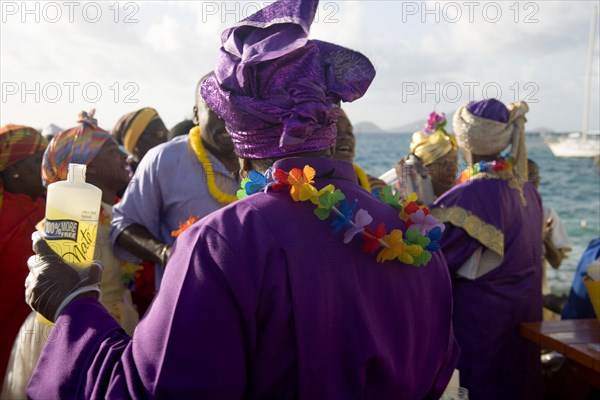 WEST INDIES, St Vincent & The Grenadines, Union Island, Woman with Holy Water amongst the Baptist congregation in Clifton at Easter morning harbourside service for those lost at sea