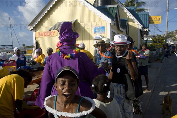 WEST INDIES, St Vincent & The Grenadines, Union Island, Woman giving blessing with Holy Water amongst the Baptist congregation in Clifton at Easter morning harbourside service for those lost at sea