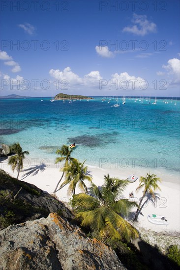 WEST INDIES, St Vincent & The Grenadines, Tobago Cays, View over the beach of Jamesby Island and moored yachts towards Canouan on the horizon