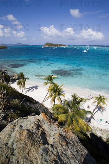 WEST INDIES, St Vincent & The Grenadines, Tobago Cays, View over the beach of Jamesby Island and moored yachts towards Canouan on the horizon