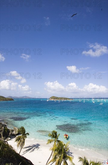 WEST INDIES, St Vincent & The Grenadines, Tobago Cays, View across the beach at Jamesby Island and moored yachts towards Canouan on the horizon
