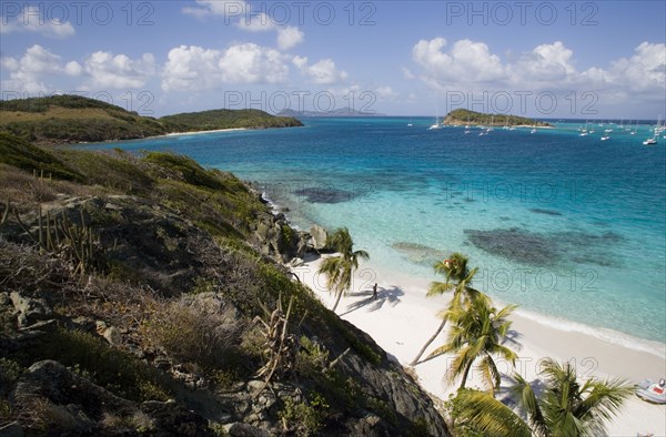 WEST INDIES, St Vincent & The Grenadines, Tobago Cays, View across the beach at Jamesby Island and moored yachts towards Canouan on the horizon