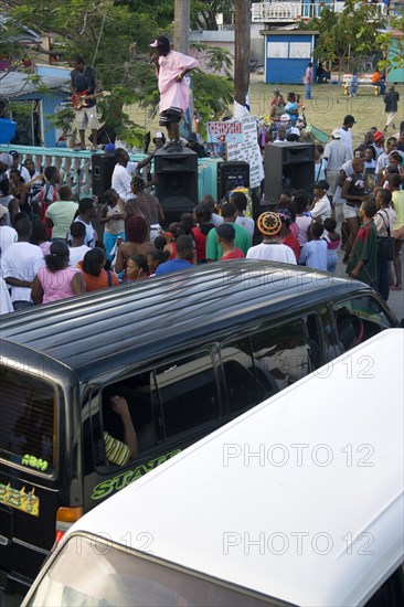 WEST INDIES, St Vincent & The Grenadines, Union Island, Singer and guitarist with sound system by busy street at Easterval Easter Carnival in Clifton