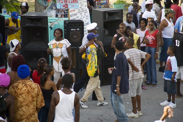 WEST INDIES, St Vincent & The Grenadines, Union Island, Policeman leading away a young man for a word beyond the sound system at Easterval Easter Carnival in Clifton