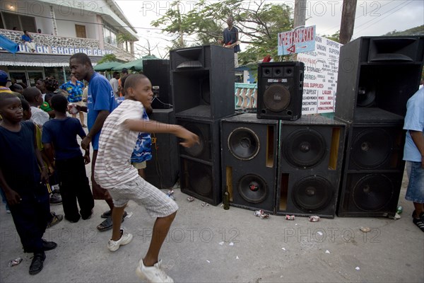 WEST INDIES, St Vincent & The Grenadines, Union Island, Boy dancing beside sound system at Easterval Easter Carnival in Clifton