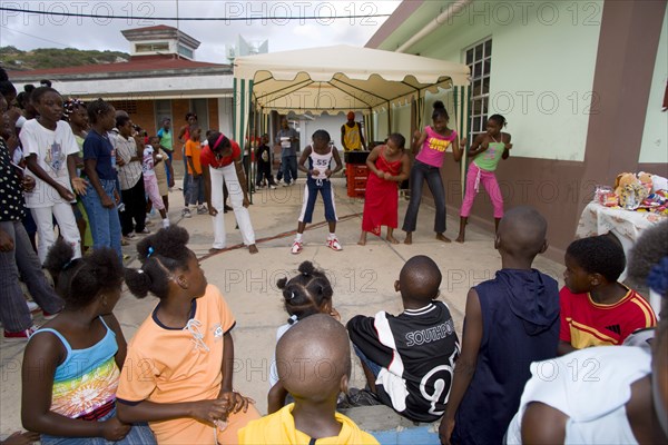 WEST INDIES, St Vincent & The Grenadines, Union Island, Children watching other children dancing to a sound system at the Easterval Easter Carnival in Clifton